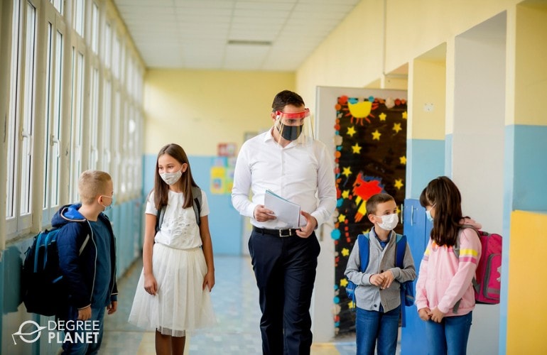 Elementary teacher walking in hallway with students