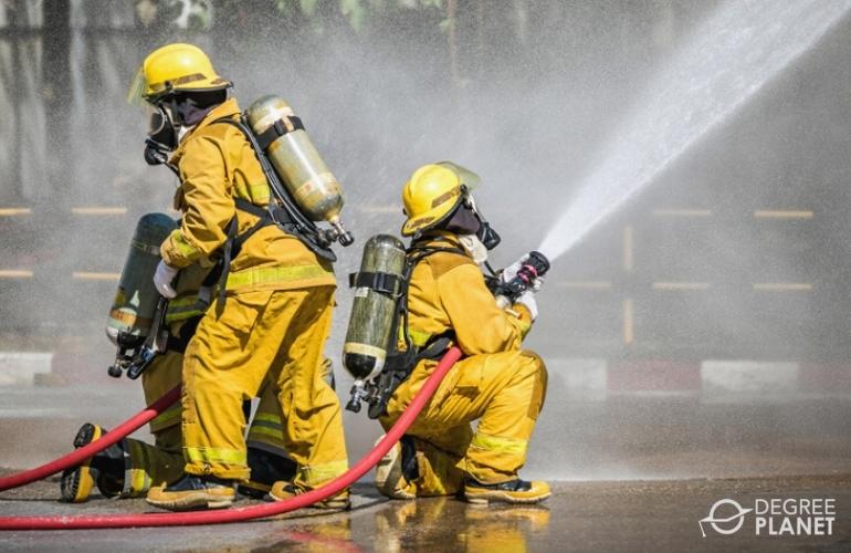 Firefighters during putting out fires with water hoses