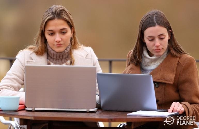 Friends checking online for Healthcare Management PhD programs