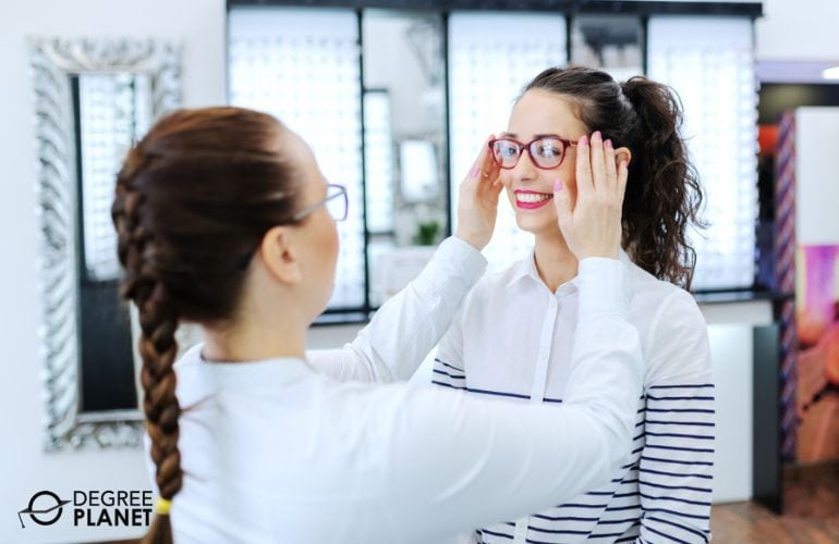 Optician fitting her customer's eyeglasses