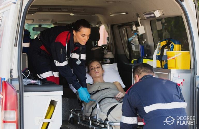 Paramedics lifting an injured woman in the ambulance vehicle