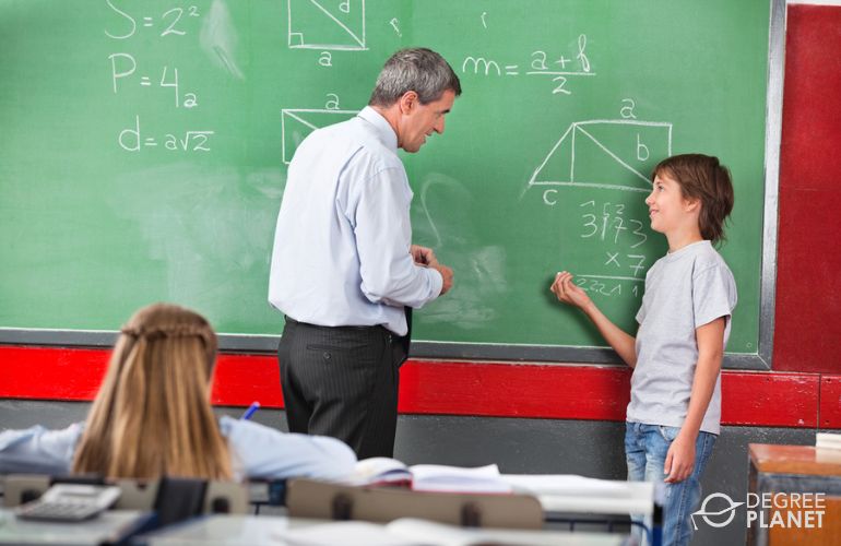Elementary Math teacher helping a student use a formula 
